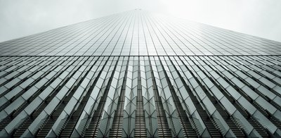 This architectural photograph showcases a modern skyscraper with a striking glass facade. The buildi