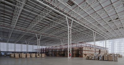 This architectural image showcases the interior of a large warehouse, characterized by its high ceil