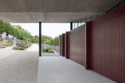 This architectural image showcases a modern structure within a cemetery setting. The design features
