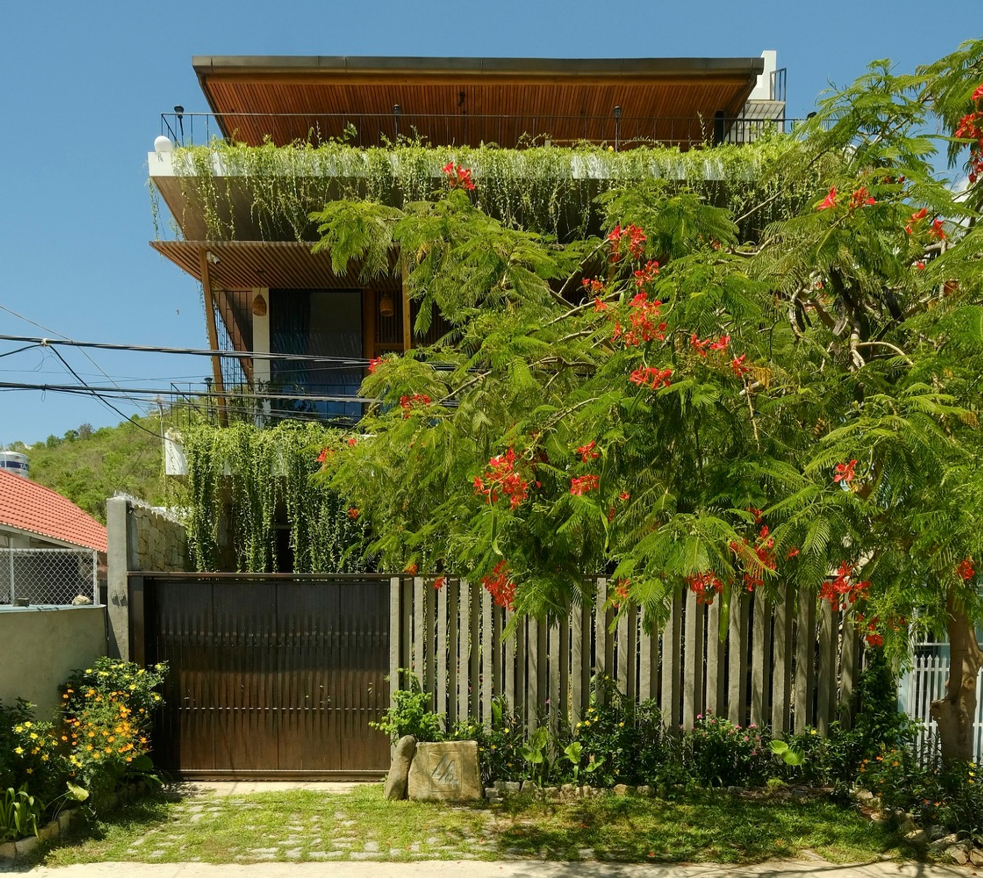 House by the River: A Harmonious Blend of Rustic and Tropical Architecture by Chơn.a