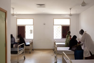 This image depicts the interior of a hospital room, characterized by its minimalist design and clini