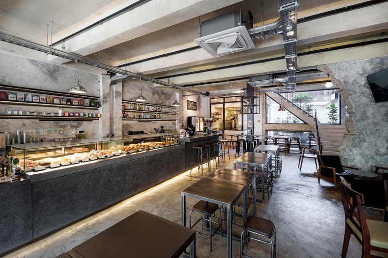Light well: removed rear balcony revealing exposed brick, concrete beams, potted tree, glass door to interior