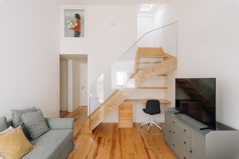 Living room with timber staircase incorporating a built-in desk and storage under skylights