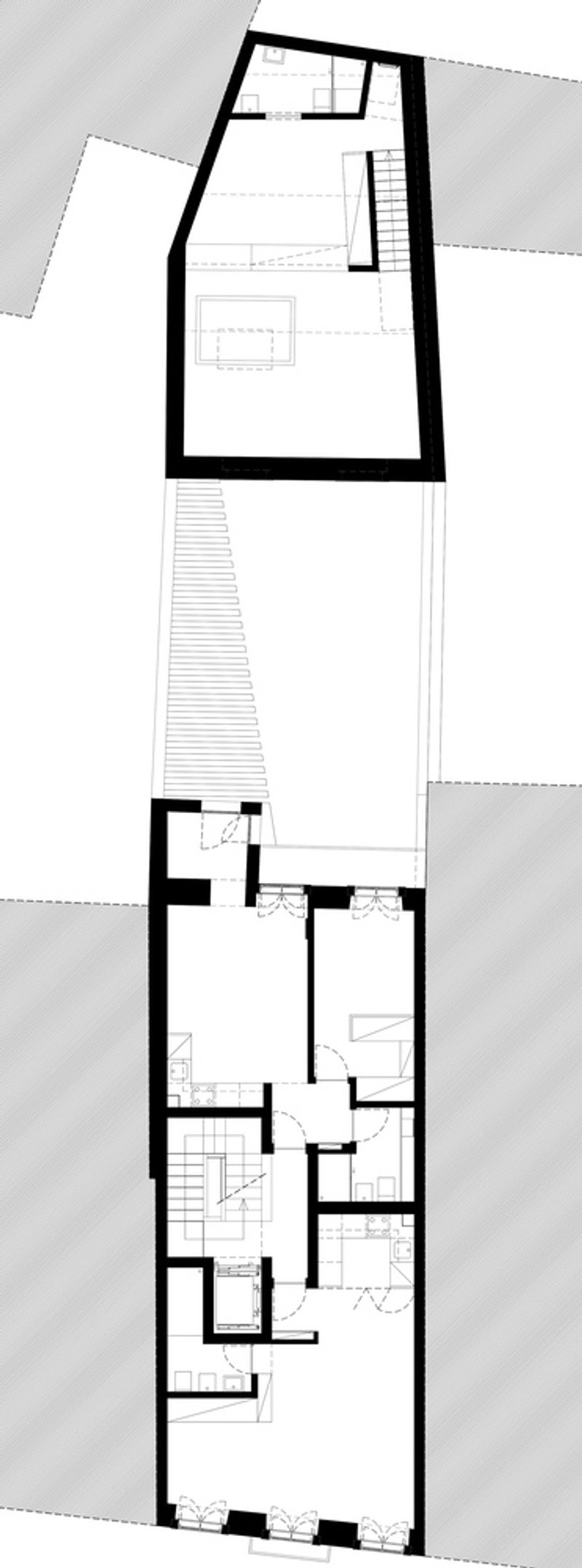Floor plan drawing showing a narrow lot with three interior volumes separated by a central courtyard