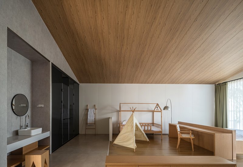 Children's room with slatted timber ceiling, black wardrobe partition, and play tent on wood floor