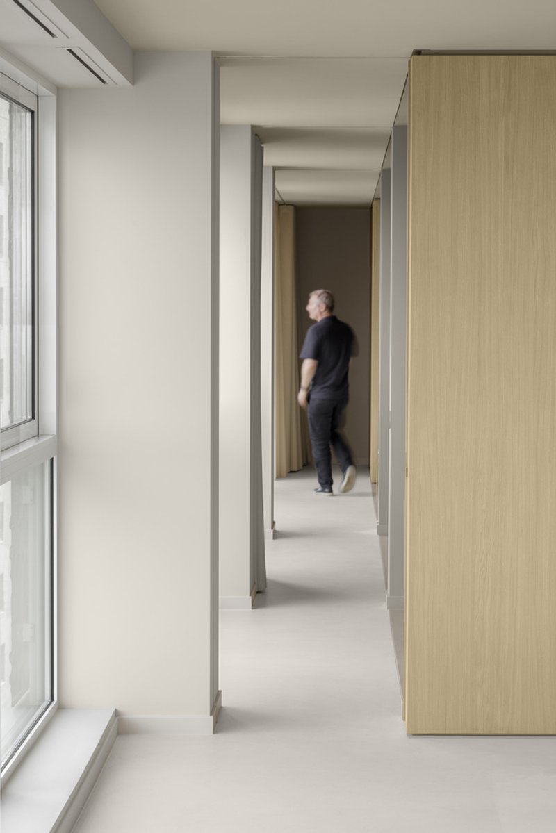 Narrow corridor with steel-framed doorways and figure walking through layered openings