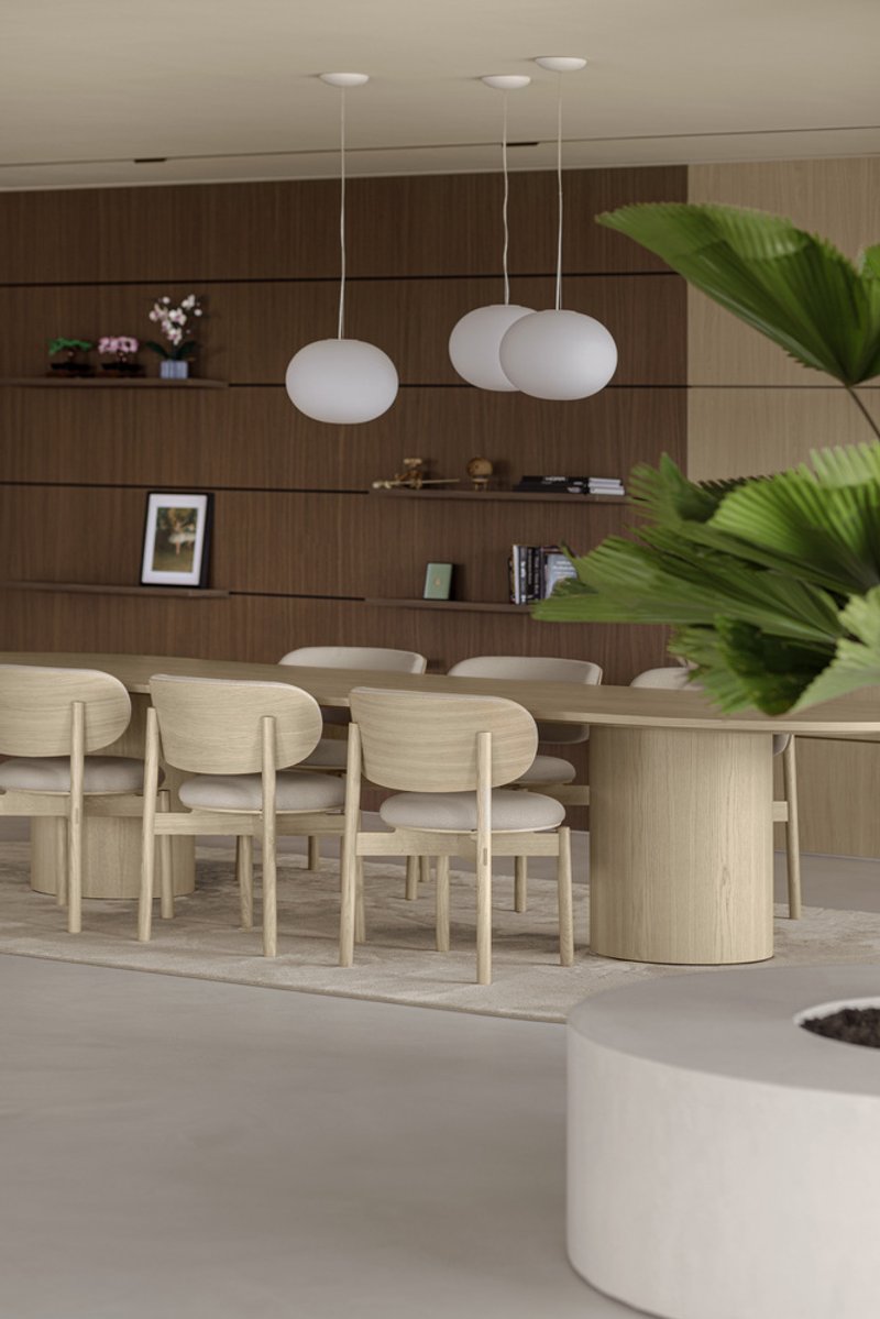 Dining table with pendant lights suspended over horizontal walnut shelving wall and palm fronds
