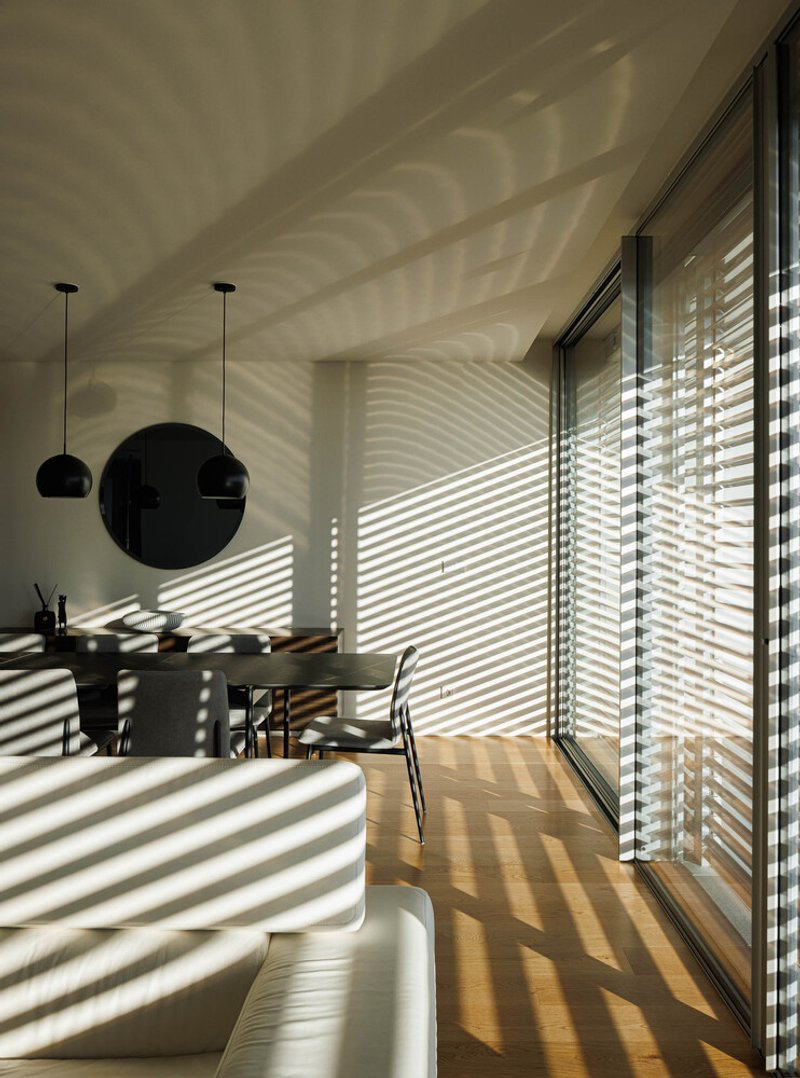 Dining area with striped shadow patterns cast by exterior louvers onto walls and floor