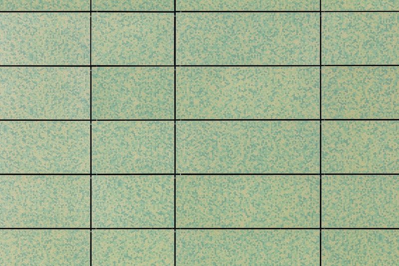 Grid of rectangular panels with mottled green and beige finish showing horizontal joint lines