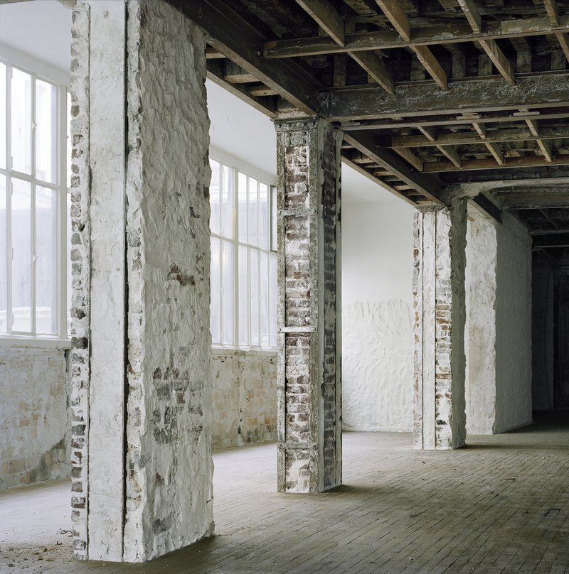 Before: stripped masonry columns and arches, exposed structure, timber ceiling joists