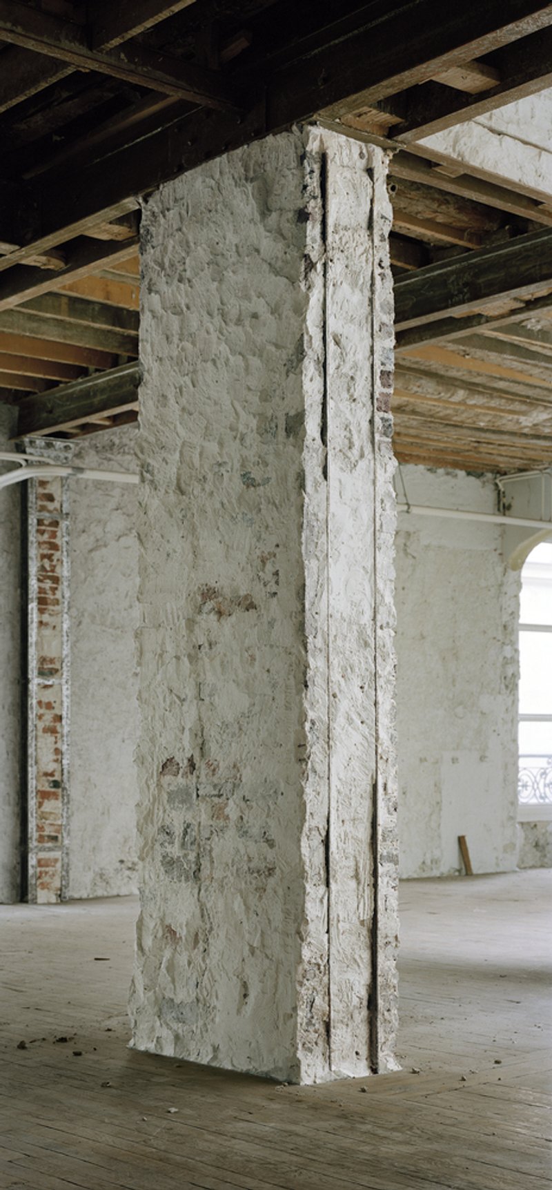 Before: stripped masonry column close-up, exposed brick and plaster layers