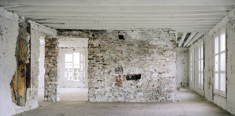 Before: upper floor, thick masonry arches, iron staircase spiral, exposed services