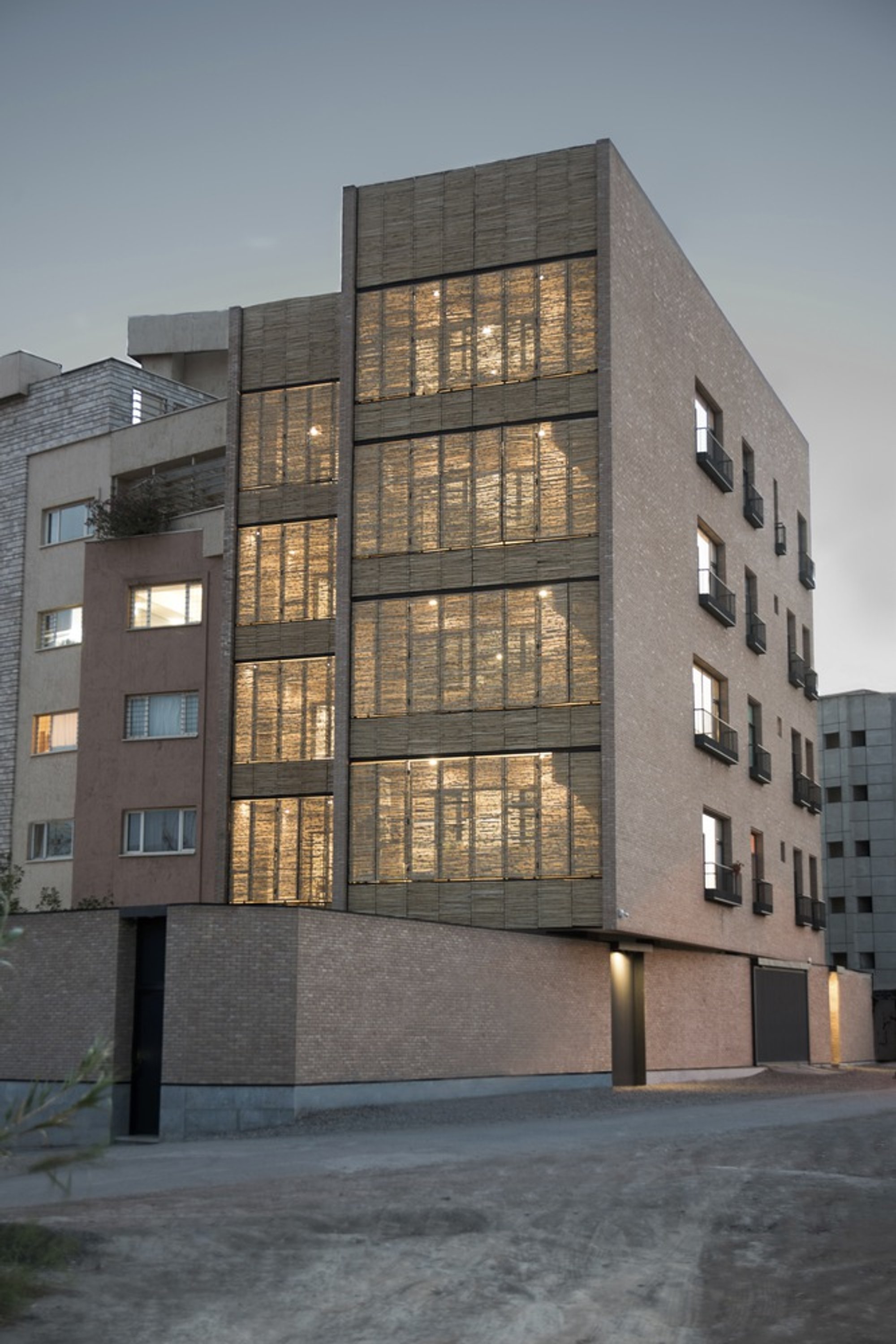 MA Office Wraps an Iranian Residential Tower in Folding Reed Screens and Handmade Brick