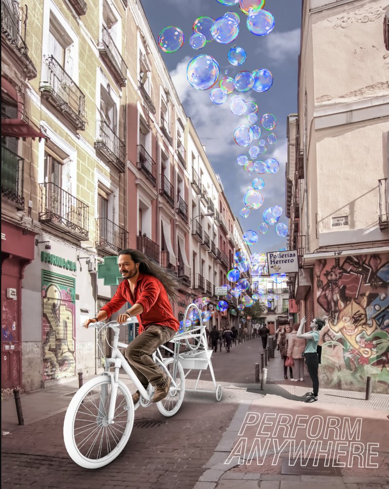 Madrid street scene: a cyclist rides down a narrow lane trailing a cloud of iridescent soap bubbles overhead, with the tagline PERFORM ANYWHERE at the bottom