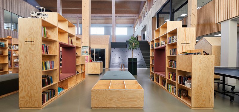Stair-shelf: plywood bookshelves built into a stepped seating structure, timber slat wall behind, reading bench