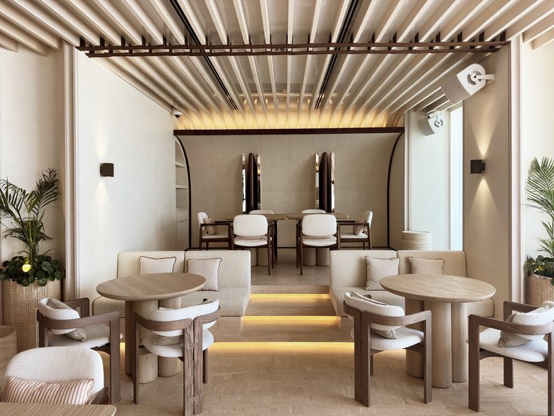Ilios ground floor: white arched ceiling with timber slat canopy, elevated seating, warm uplighting