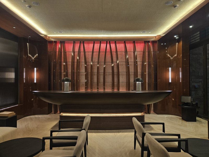 Nalu bar at night: dark timber bar counter with red-lit vertical timber screen behind, black seating