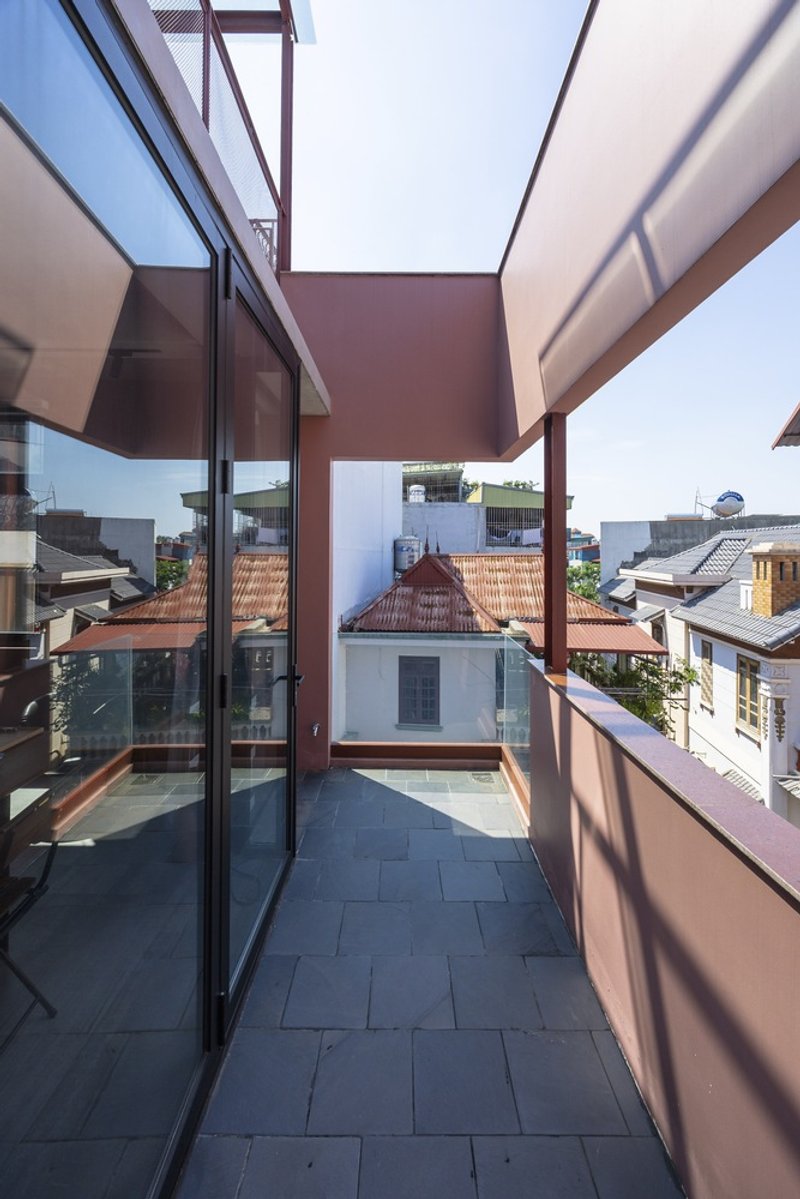 Upper terrace with dark tile paving and steel frame opening to tiled rooftops beyond
