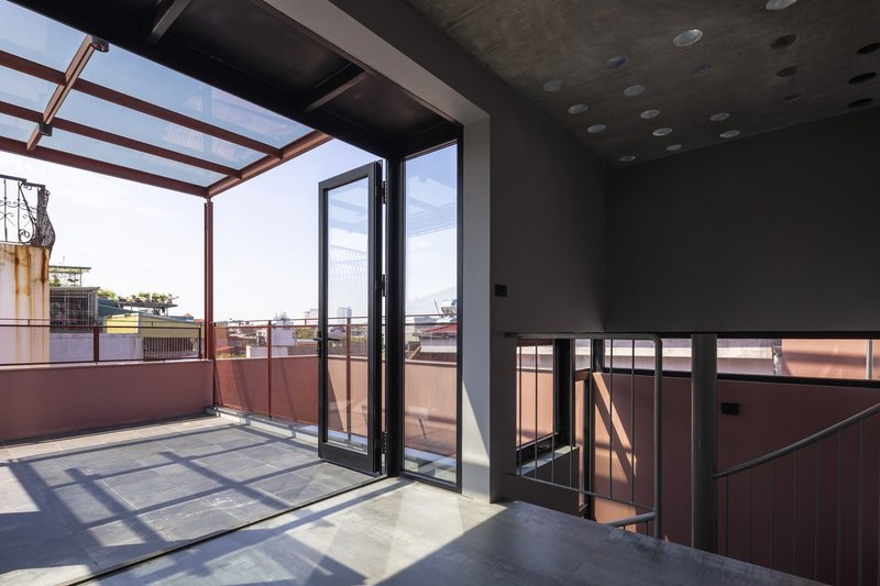 Upper level terrace with steel frame canopy opening to rooftops under afternoon light