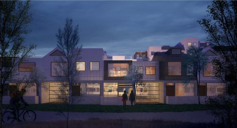 Street-facing elevation at night: warmly lit windows in a composition of varied rooflines and facade materials, with a cyclist, a couple, and trees in the foreground