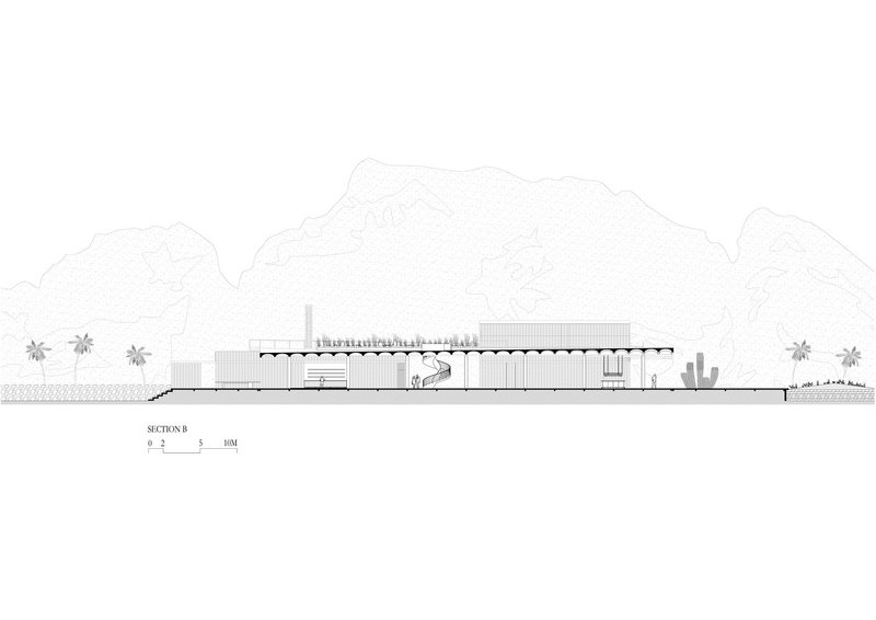 Section drawing showing a low horizontal building with exposed structural trusses and desert landscape with cacti and mountains