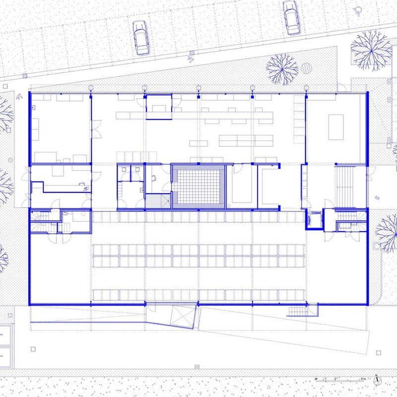 Floor plan drawing showing office spaces surrounding a central courtyard with parking and trees along the street
