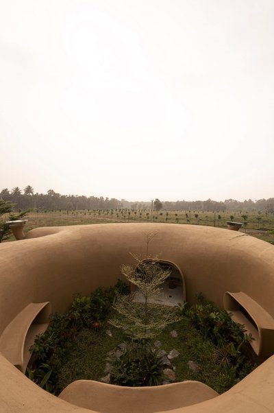 This architectural image showcases an earth-sheltered structure with a curvilinear design, seamlessl