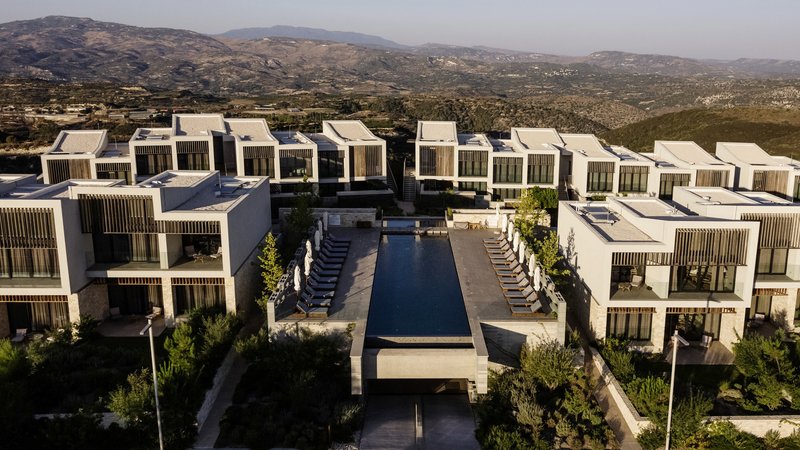 Aerial view of the residential complex with central pool deck surrounded by hillside landscape
