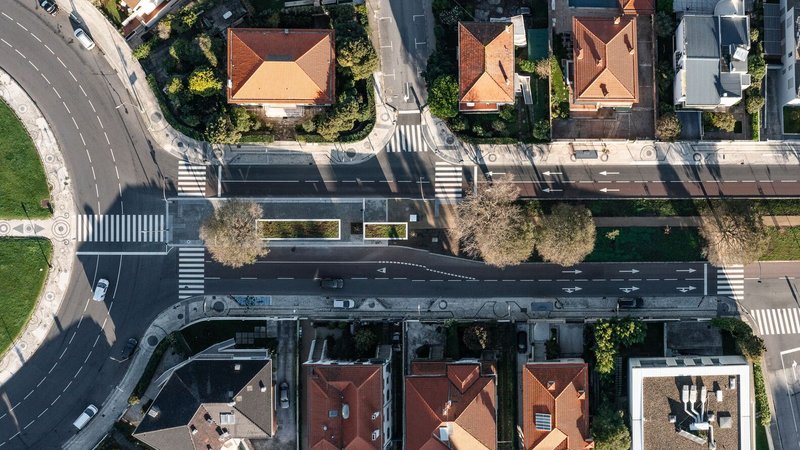 Aerial view of a dark linear structure spanning a street intersection with pedestrian crossings