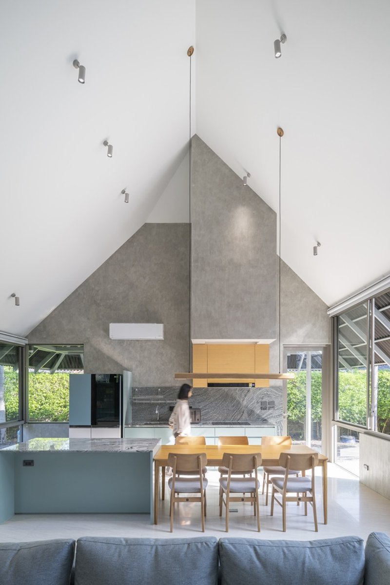 Interior view of the dining area with pitched concrete ceiling and a person moving through the space