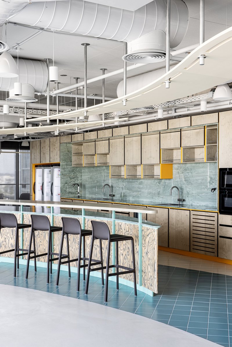 Breakfast bar with turquoise tile base and mint green marble backsplash under exposed ductwork