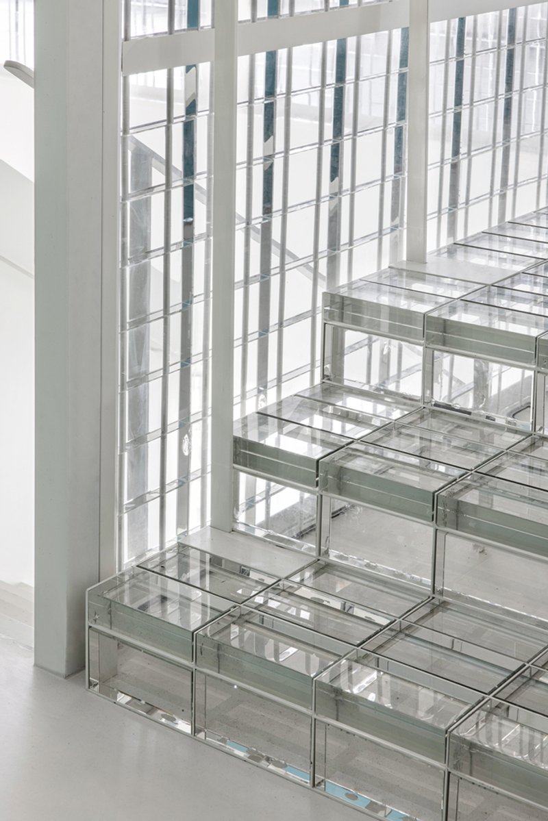 Detail of glass block stair treads meeting a vertical translucent screen wall