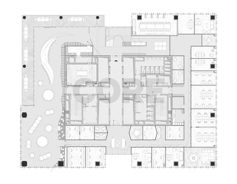 Floor plan drawing showing curved central staircase and scattered workstations within an irregular perimeter with outdoor terrace