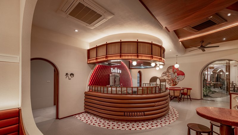 Circular service counter with horizontal timber slats beneath a suspended timber ring and coffered ceiling