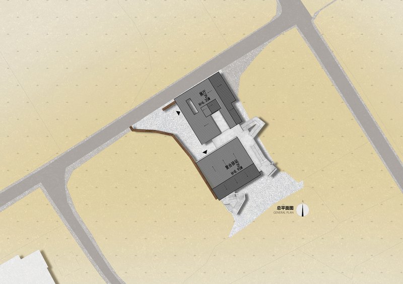 Site plan drawing showing two connected rectangular volumes surrounded by pathways and gravel surfaces
