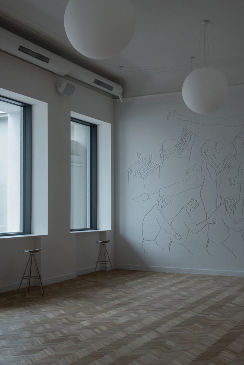 Interior room with parquet floor, figurative wall drawing, spherical pendant lights and two deep-set windows