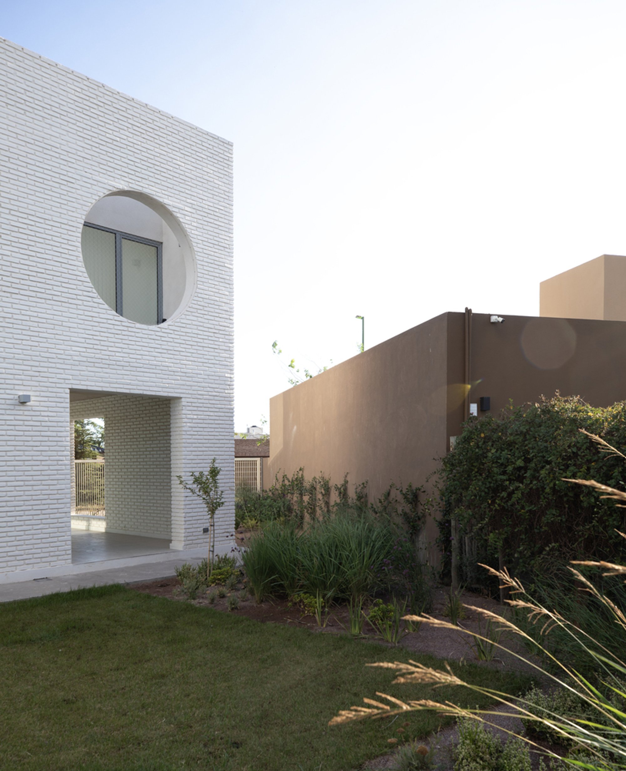 FLORA Carves Circular Openings into a White Brick House in Brazil
