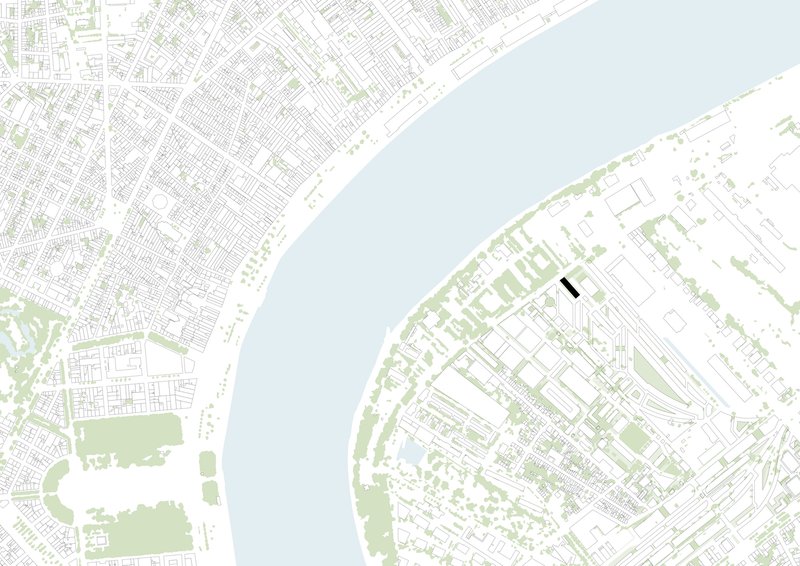 Site plan drawing showing a narrow building footprint between dense urban fabric and a curving waterfront