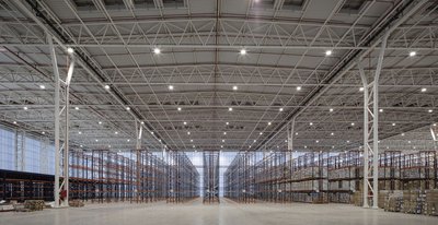 This architectural image showcases the interior of a large warehouse, characterized by its high ceil