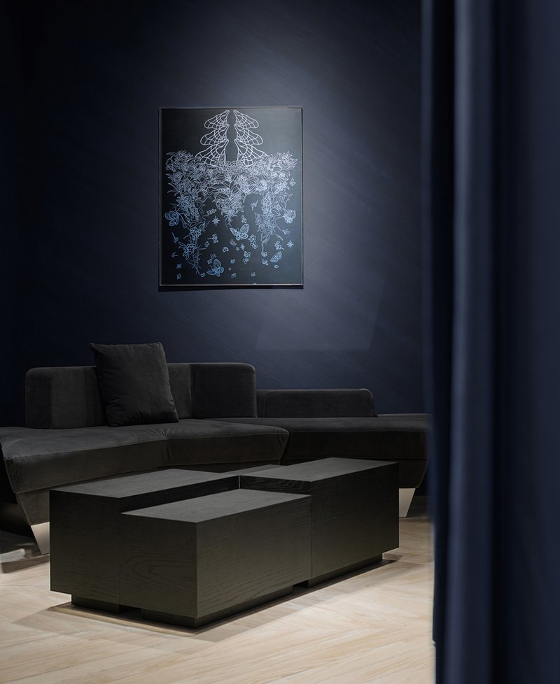 Seating area with charcoal sofa and backlit jellyfish artwork on a blue wall