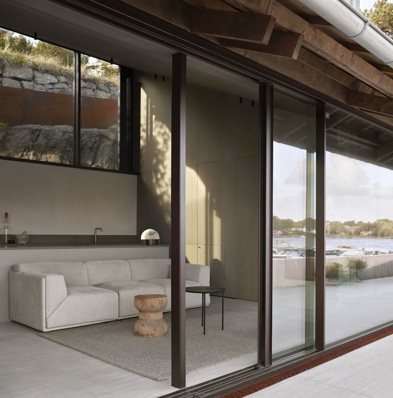 Sliding glass doors opening from the living area to a terrace with dappled afternoon sunlight