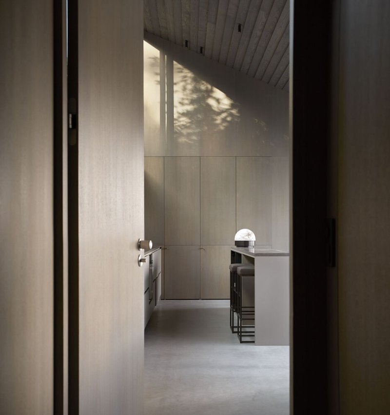 View through doorway into the kitchen with timber ceiling and dappled afternoon sunlight