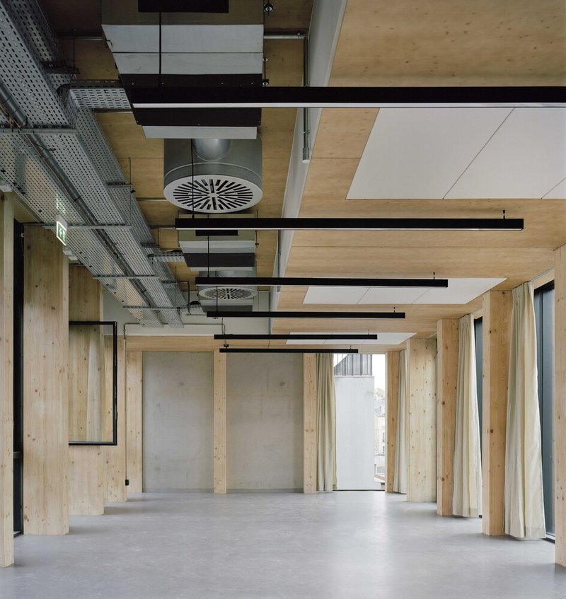 Ceiling detail showing timber panels, exposed black beams, round ventilation diffuser and pendant fixtures