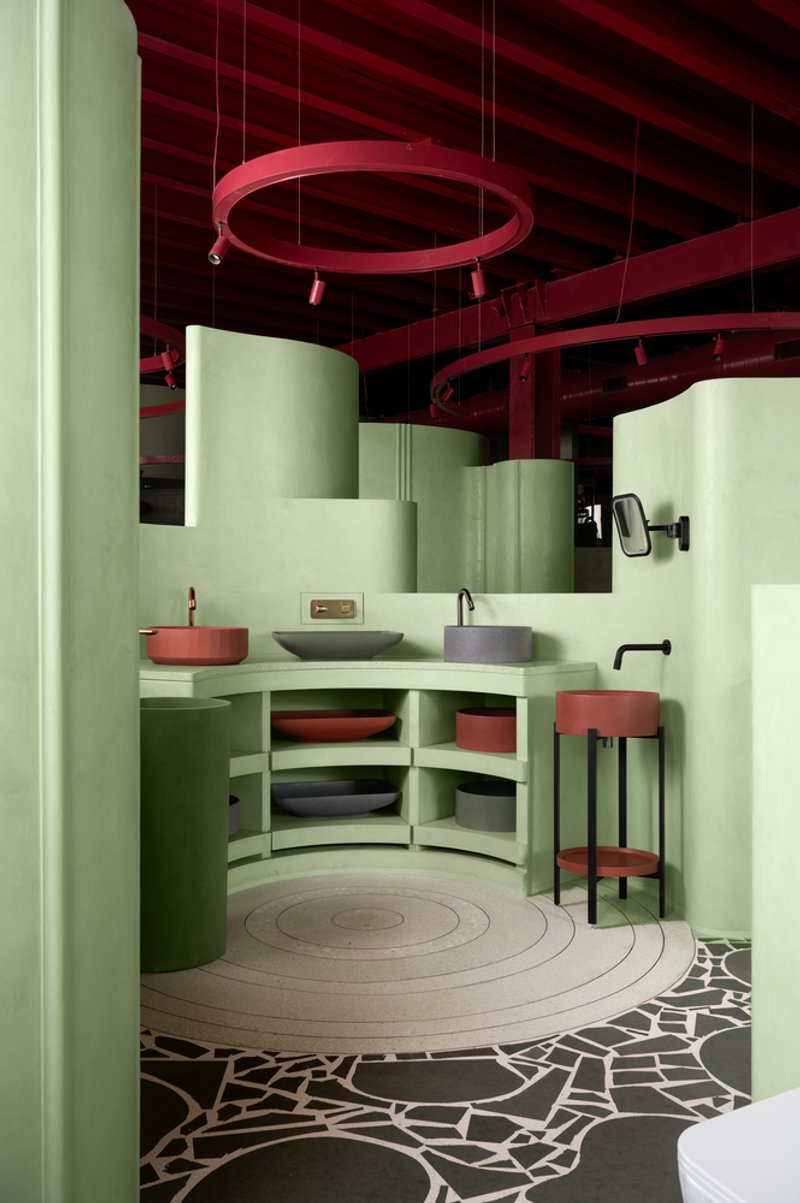 Corner vanity with vessel sinks and circular floor inlay meeting graphic tile pattern