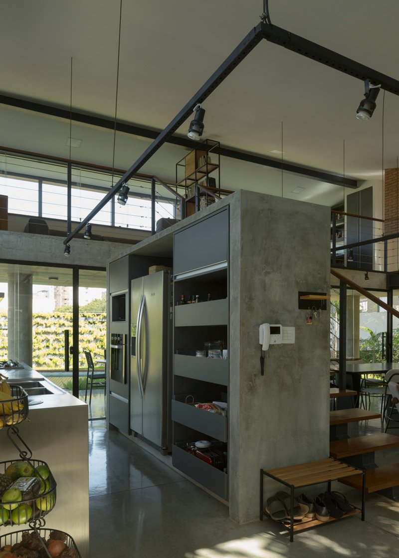 Open kitchen with concrete walls, exposed steel beams and clerestory windows overlooking vertical garden wall