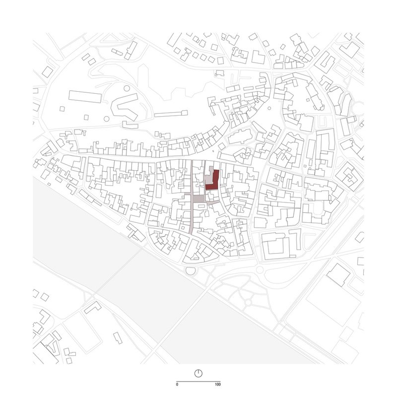 Site plan drawing showing a single highlighted building footprint within a dense urban fabric of streets and blocks