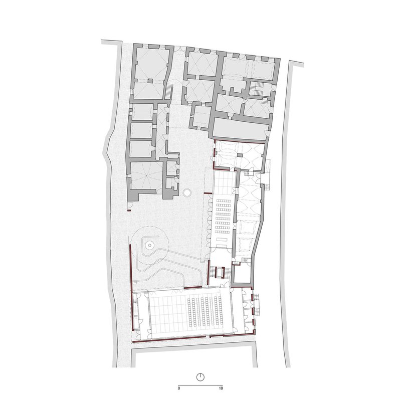 Floor plan drawing showing interior rooms and a courtyard with circular water feature and seating grid