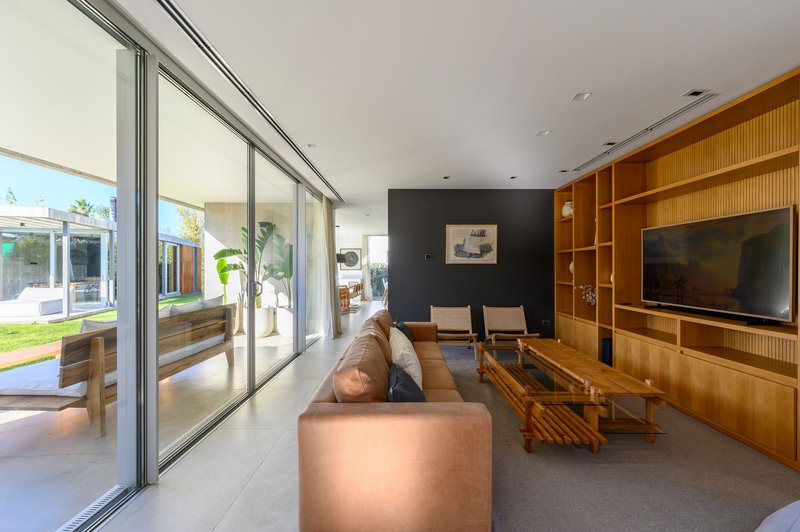Living room with floor-to-ceiling glass doors opening to the garden and timber built-in shelving