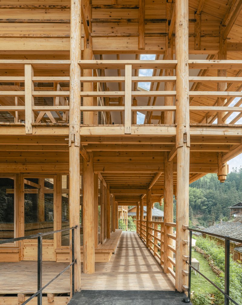 Long timber corridor with horizontal railings and exposed beams overlooking the surrounding landscape