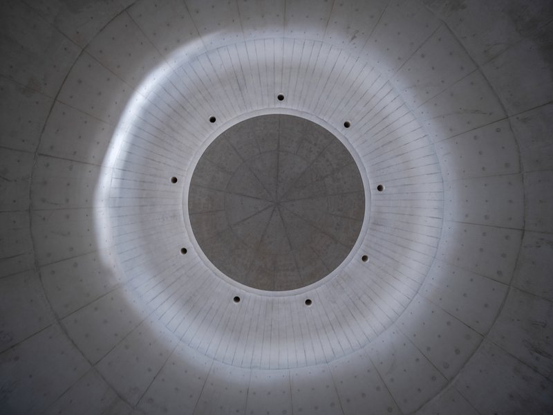 Looking up at circular oculus with concealed perimeter lighting in concrete dome